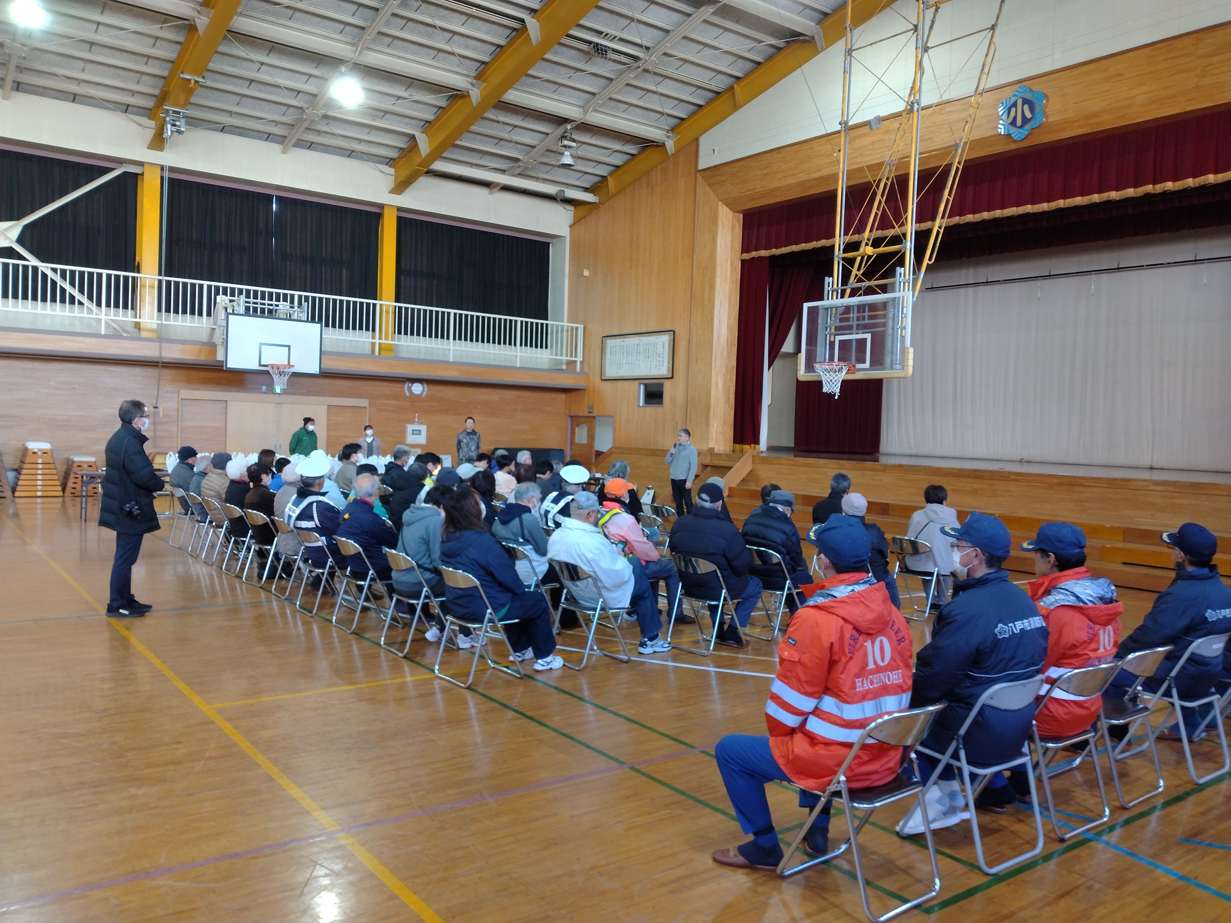 高館小学校の体育館で段ボールベッドと簡易テントを組み立てる様子