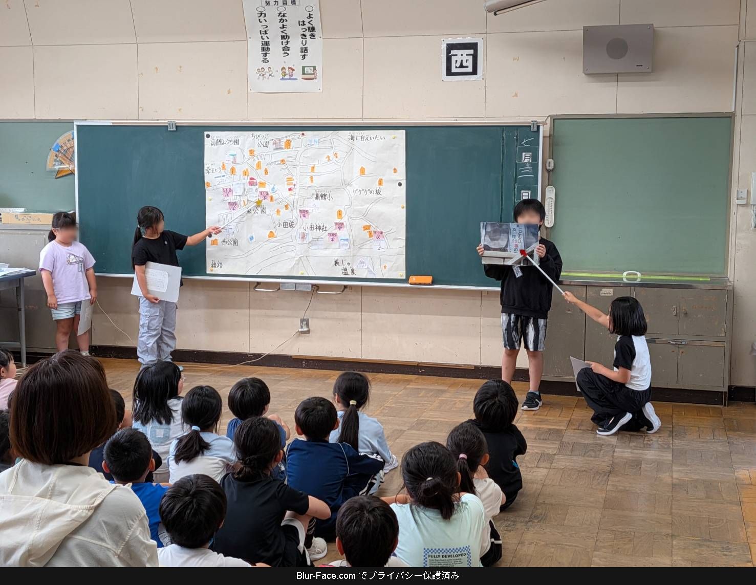 地域と学校が一緒に作った安全マップと笑顔の集合写真